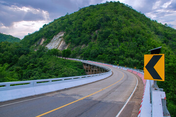 long road leading towards mountain in Thailand.