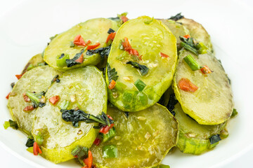 Fried cucumbers with perilla on a plate on a white background
