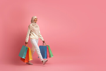Big Sales Concept. Smiling Muslim Woman In Hijab Walking With Shopping Bags