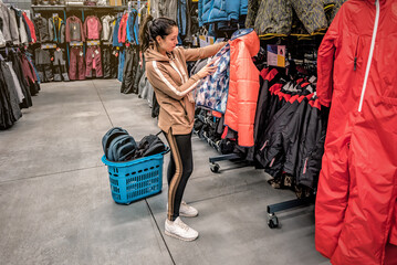 Woman chooses winter jacket in the sport store