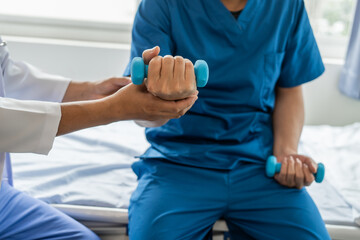 Fototapeta premium Using dumbbell, Physiotherapy specialists help patients in physiotherapy. about Muscle Weakness and Fatigue