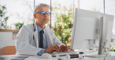 Healthcare Doctor Using Desktop Computer for Day-to-Day Hospital Operations. Clinic Professional...