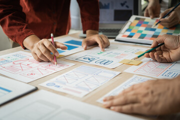 Group of asian creative team programing designers participate in all phases of the UX design.