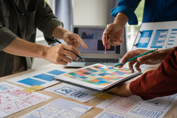 Group of asian creative team programing designers participate in all phases of the UX design.
