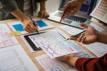 Group of asian creative team programing designers participate in all phases of the UX design.