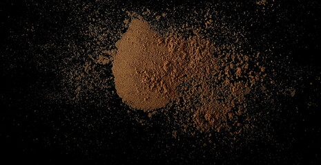 Coriander ground scattered isolated on black, top view ,