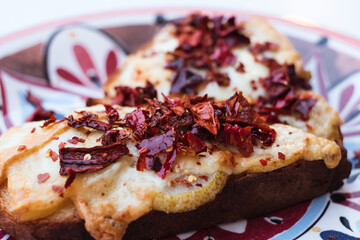 Traditional Matera Italy antipasti appetizer - bruschetta with homemade bread, caciocavallo podolico cheese, pear and dried peppers powder