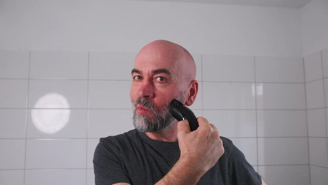 Senior man shaving his beard