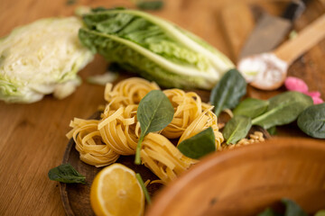 Fresh spinach leaves with raw pasta, close-up