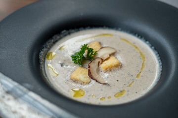 Mushroom soup served in black bowl in the restaurant