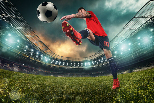 Football scene at night match with player kicking the ball with power