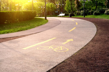 Obraz premium Highlighted with yellow paint cycle path in the city park.