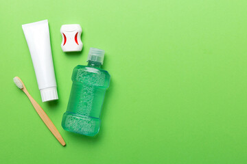 Mouthwash and other oral hygiene products on colored table top view with copy space. Flat lay. Dental hygiene. Oral care products and space for text on light background. concept