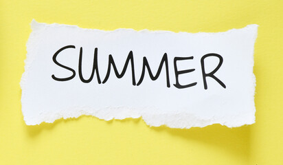 The word Summer on a small piece of paper and a yellow background.