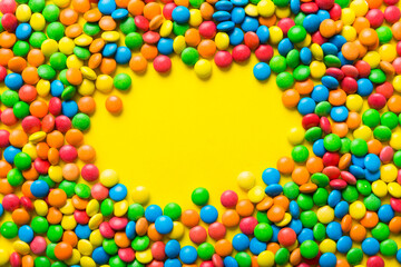 Mixed collection of colorful candy, on colored background. Flat lay, top view. frame of colorful chocolate coated candy
