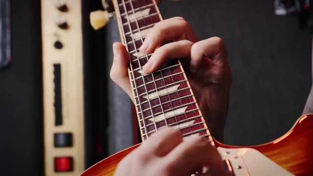 Guitarist playing music on guitar in professional sound studio. Vertical video