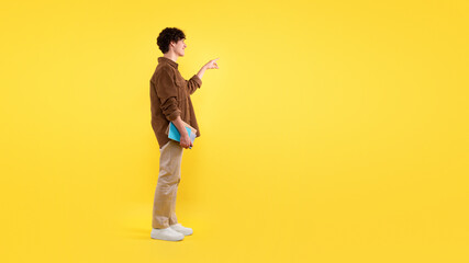 Student Guy Pointing Finger Aside At Free Space, Yellow Background