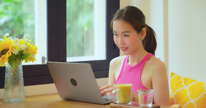 Freelance woman working in a cafe or restaurant alone. She uses the computer to work and search for information in restaurants.