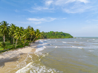 The ariel view of the clear sky with palm trees, fine sand and foam waves splashed to serene beach...