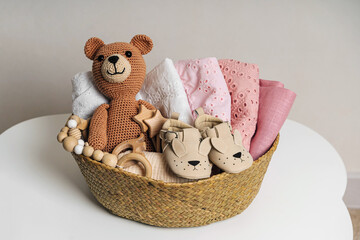 Basket with baby stuff and accessories for newborn. Gift basket with cotton clothes and muslin...