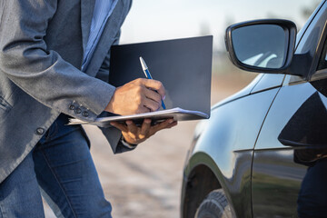 Insurance agent inspecting a car and taking notes. © jroballo
