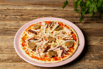 Plate with a pizza ready to bake, with vegetables, tuna, cooked ham and anchovies, close-up.