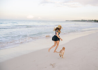 girl with her puppy in front of the beach