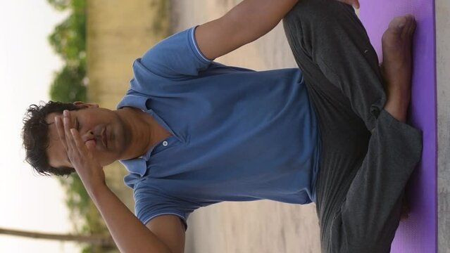 Indian man doing Anulom Vilom exercises breathing exercises, pranayam exercise, yoga for fitness.