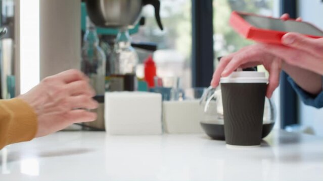 Close-up: a customer makes a purchase in a coffee shop, pays with a QR code. Scans the QR code with a smartphone in the bank's application. New technologies in digital finance. Electronic payment