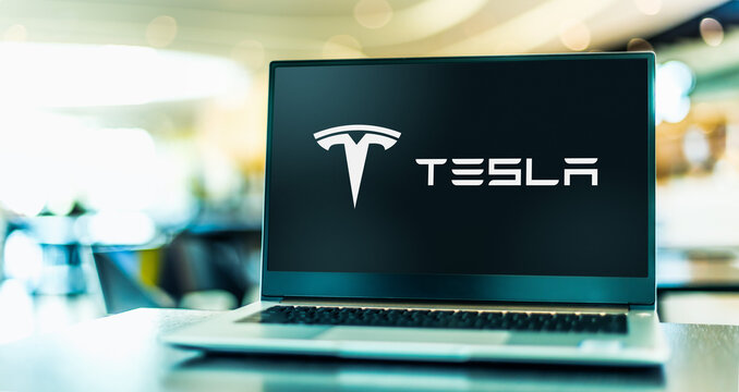 Laptop computer displaying logo of Tesla