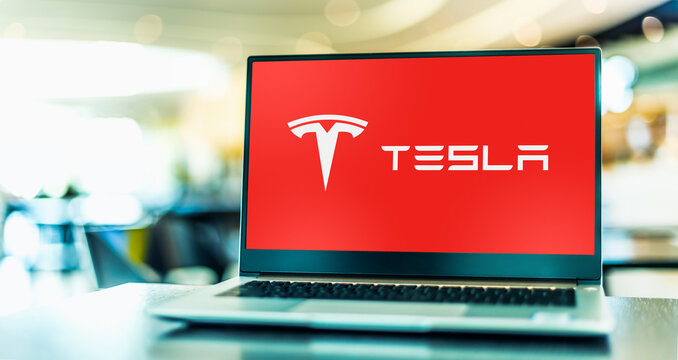 Laptop computer displaying logo of Tesla