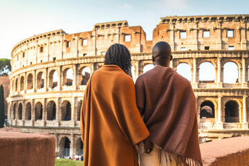 Fototapeta na wymiar African american couple against Colosseum, Rome, Italy. Tourists in love, visiting italian famous landmarks. Generative AI.
