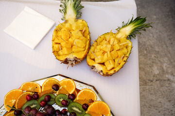 exotic and tropical fruit in summer holidays aerial view. Pineapple, cherries, kiwi and oranges.