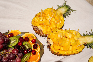 exotic and tropical fruit in summer aerial view. Pineapple, cherries, kiwi and oranges. Summertime and holidays
