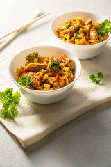 Stir-fried egg noodles with chicken breast in a bowl, top view