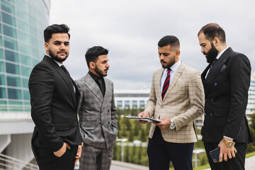 Business people outdoor meeting. Portrait of a business man against the background of a group of people and buildings of the city center
