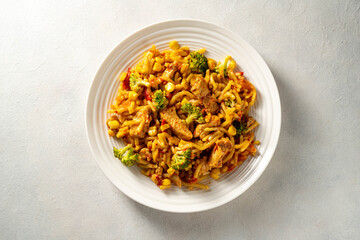 Stir-fried egg noodles with chicken breast in a white plate top view