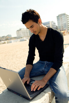 Young man using a personal computer while sitting outdoor