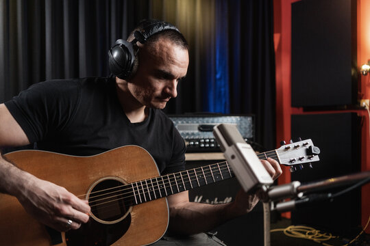 Musician Playing Guitar In The Music Studio - Powered by Adobe