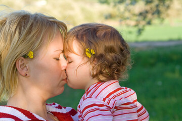 Baby girl kissing her mother