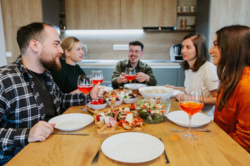Dinner with friends in a modern home. Smiles and liveliness.