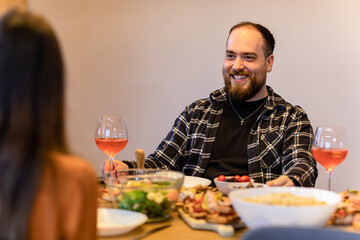 Obraz premium Couple having intimate dinner, focus on the man, uplifting smile.
