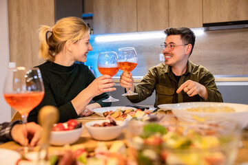 Radiant Couple having a dinner at home, holding a toast with wine.