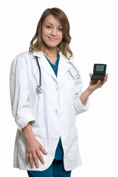 Woman doctor in wearing a doctors lab coat holding up  an open pager showing blank screen standing on white