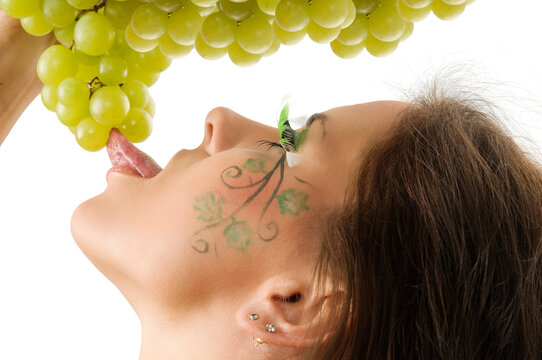 sexy brunette with a nice draw on her face licking green grape