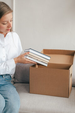 Tranquil woman unpacking books on sofa