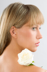 Naklejka premium fresh portrait of a young pretty woman with a rose on her shoulder