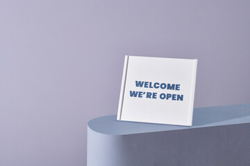 Welcome We're Open typography text on the whiteboard