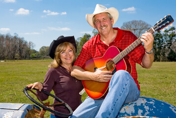 Obraz na płótnie Canvas Beautiful mature couple in cowboy hats on the farm.