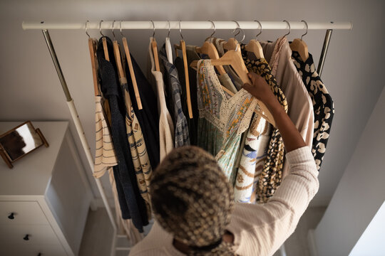 Crop black woman picking outfit from rack